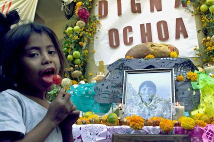 A child is seen in front of an altar honoring Dign
