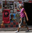 An elderly woman walks in a street of Havana