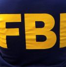 An FBI logo is pictured on an agent's shirt