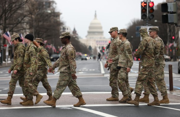 US Army soldiers walk in front of the US Capitol