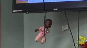 Black doll tied in a cord